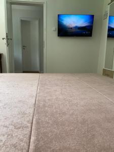a room with a flat screen tv on the wall at Old town Suburb Apartment in Sarajevo +13 photos