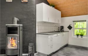 a kitchen with a stove with a fire in it at 4 Bedroom Lovely Home In Vestervig in Vestervig +24 photos