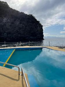 a swimming pool with a view of the ocean at Casa da Adega in Ribeira Chã
