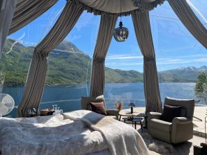 a bedroom with a view of a lake and mountains at Lofoten Glamping Dome in Myrland
