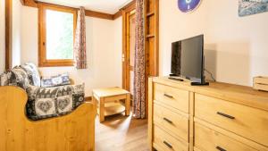 a living room with a tv on a wooden dresser at Le Chalet De Montchavin - Magnifique appartement rénové MAE-4234 in La Plagne Tarentaise