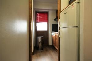 une cuisine avec un réfrigérateur blanc et une fenêtre dans l'établissement Le Chalet De Montchavin - Bel appartement sous pentes MAE-4324, à La Plagne Tarentaise