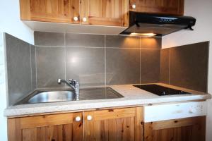 une cuisine avec un évier et une cuisinière dans l'établissement Le Chalet De Montchavin - Bel appartement proche du centre MAE-4354, à La Plagne Tarentaise 7 autres photos