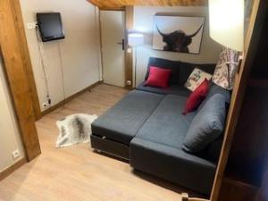 a living room with a black bed with red pillows at Le Chalet De Montchavin - Bel appartement sous les toits vue Mont Blanc MAE-4414 in La Plagne Tarentaise