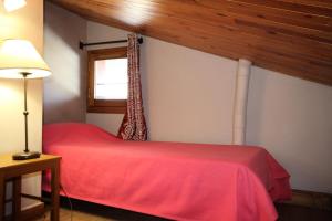 a bedroom with a red bed and a window at Le Chalet De Montchavin - Bel appartement sous les toits vue Mont Blanc MAE-4414 in La Plagne Tarentaise