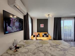 a bedroom with a large bed with a tv on the wall at студио Водолей in Obzor