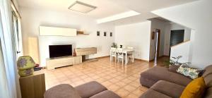 a living room with a couch and a tv and a table at Casa Pepe Las Candelarias in Agaete