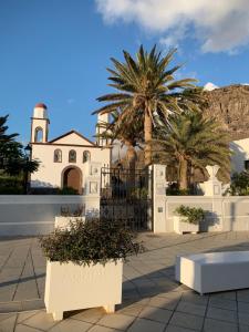 a white house with palm trees in front of it at Casa Pepe Las Candelarias in Agaete