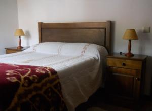 a bedroom with a bed and two night stands with lamps at Latada Suit's Serra da Estrela in Sameiro