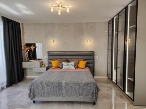 a bedroom with a large bed with orange pillows at студио Водолей in Obzor