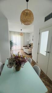 a living room with a blue table with flowers on it at Altos de Jerez & Parking Privado in Jerez de la Frontera