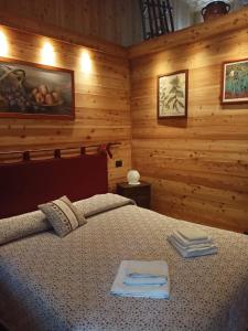 una camera da letto con un letto con asciugamani sopra di L'Alpina Affittacamere a Bobbio Pellice