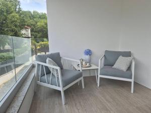 two chairs and a table on a balcony at Luxury apartment Jakov in Njivice