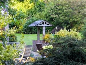a garden with two chairs and an umbrella at Blackwell House in Banbridge