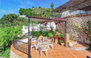 フリヒリアナにあるAwesome Home In Frigiliana With Wifiの石壁のパティオ(テーブル、椅子付)