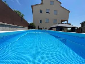 a blue swimming pool in front of a building at Apartment Bellevue in Vodnjan
