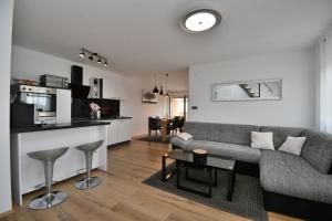 a living room with a gray couch and a kitchen at Apartment Bellevue in Vodnjan