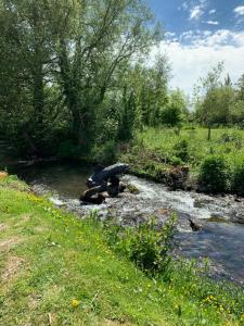 a stream of water with rocks in a field at Weston glamping pod in Oswestry
