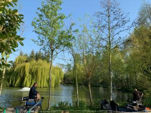 two men sitting on chairs in front of a river at Weston glamping pod in Oswestry