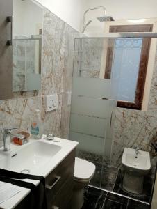 een badkamer met een wastafel, een toilet en een spiegel bij Villa Cesarea in Porto Cesareo