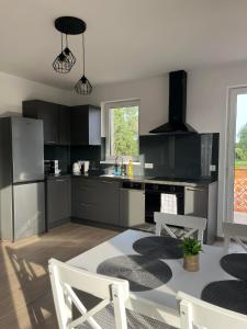 a kitchen with black cabinets and a table and chairs at Lux Penthouse Balatonlelle in Balatonlelle