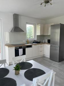 a kitchen with white cabinets and stainless steel appliances at Lux Penthouse Balatonlelle in Balatonlelle +2 photos