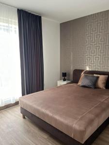 a bedroom with a large bed and a window at Lux Penthouse Balatonlelle in Balatonlelle