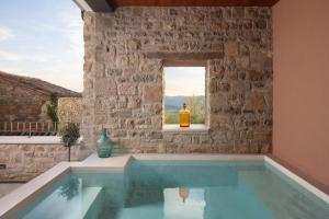 a swimming pool in a stone building with a window at Luxury Villa Motovun in Motovun