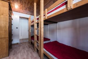 sypialnia z 2 łóżkami piętrowymi i czerwoną pościelą w obiekcie Résidence Chaudes Almes - Appartement lumineux·Proche pistes·Balcon MAE-2834 w mieście Tignes