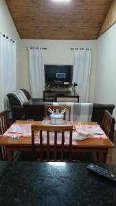 a living room with a table and a television at Casa em São Francisco Xavier sp in São Francisco Xavier
