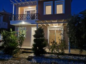 a blue house with a balcony at night at Oikies in Prinos