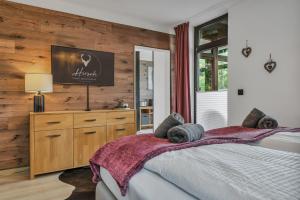 a bedroom with a bed with a tv on the wall at HIRSCH Stadt Apartment 1 - Terrasse mit Flussblick - Parkplatz in Bad Harzburg