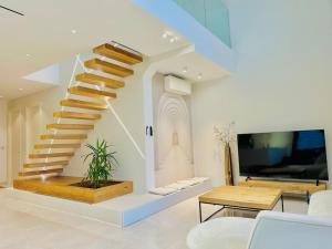 a living room with a staircase and a tv at La Villa du Vignoble d Alsace in Bennwihr