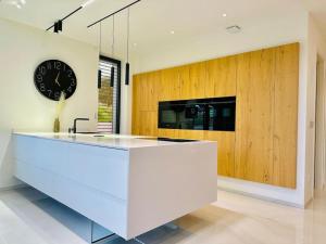 a large kitchen with a large clock on the wall at La Villa du Vignoble d Alsace in Bennwihr