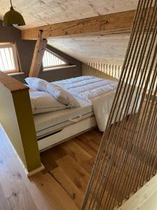 una cama en una habitación con techo de madera en Le gîte Samezo, en Villers-le-Lac