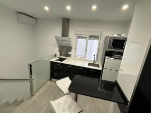 a small kitchen with a sink and a microwave at Conil Playa 200 metros Casa barrio de los pescadores in Conil de la Frontera