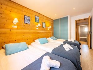 three beds in a room with wooden walls at Chalet Millonex - Duplex rénové·skis aux pieds·WIFI·Cheminée MAE-4964 in Tignes