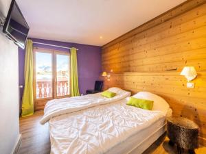 a bedroom with two beds and a wooden wall at Chalet Millonex - Appartement rénové·skis aux pieds·WIFI·Balcon MAE-4984 in Tignes