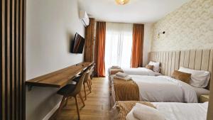 a hotel room with two beds and a desk at Villa Alba Apartments in Dobra Voda
