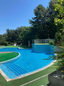 a swimming pool with blue water in a park at Milushevi apartment in Golden Sands