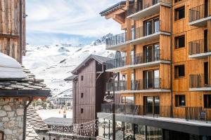 - un bâtiment avec vue sur une montagne enneigée dans l'établissement Résidence Le Rosset - 3 Pièces pour 6 Personnes MAE-0504, à Tignes