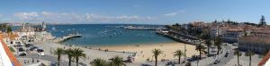 a beach with a group of people in the water at Apartment Outeiro da Vela in Cascais