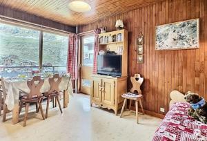 a dining room with a table and chairs and a tv at Résidence Kandahar - Agréable 2 pièces de 32m2 sur les pistes du Lavachet MAE-0244 in Tignes