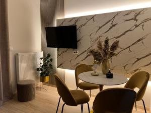 a dining room with a table and chairs and a television at Oasis Apartment 2 by GG in Alexandroupoli