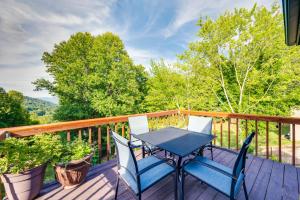 a table and chairs on a deck with trees at The Getaway Lodge in the Blue Ridge Mountains near Roanoke & Bedford in Troutville