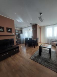 salon z kanapą, stołem i krzesłami w obiekcie Apartament Fredry 9 Zielone Tarasy w Kołobrzegu