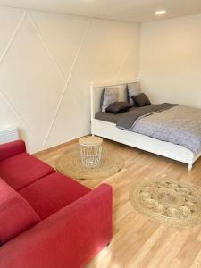 a bedroom with a bed and a red couch at Danielle et octave in Clermont