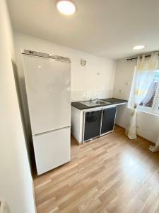 a kitchen with a white refrigerator and a wooden floor at Danielle et octave in Clermont
