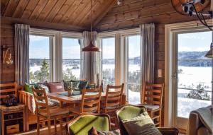 a dining room with a table and chairs and windows at 3 Bedroom Lovely Home In Nissedal in Kyrkjebygdi