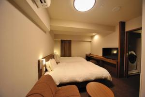 um quarto de hotel com uma cama e uma televisão em Dormy Inn Express Meguro Aobadai Hot Spring em Tóquio